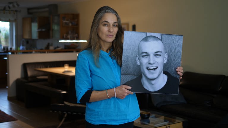 Zine hält ein Foto ihres verstorbenen Sohnes Marvin in den Händen