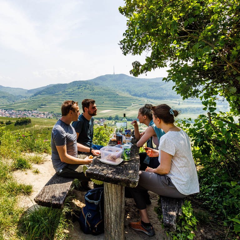 Eine Gruppe Wanderer macht auf einer Bank Pause | Tipps für Ausflüge & Veranstaltungen an Pfingsten in Rheinland-Pfalz